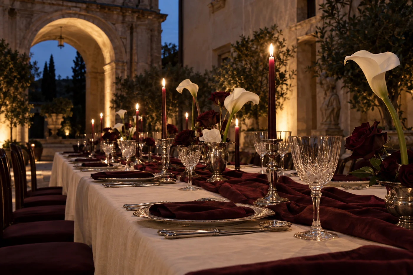 Atmosfera immaginata per il ricevimento: una corte italiana, calle e candele burgundy.