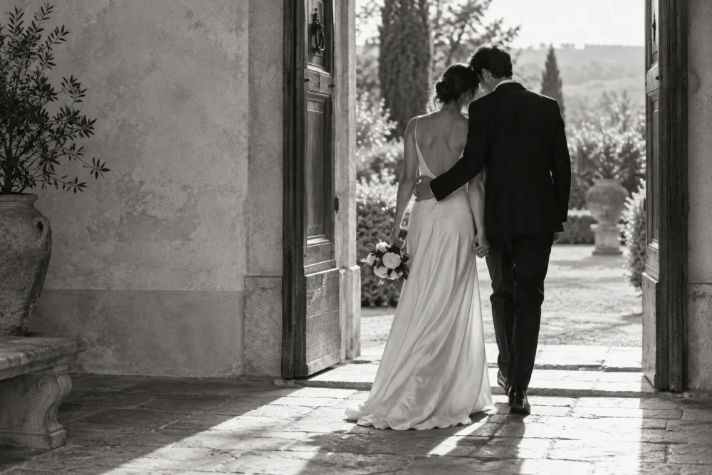 Due sposi abbracciati sulla soglia di una villa. Immagine originale, coppia di fantasia.
